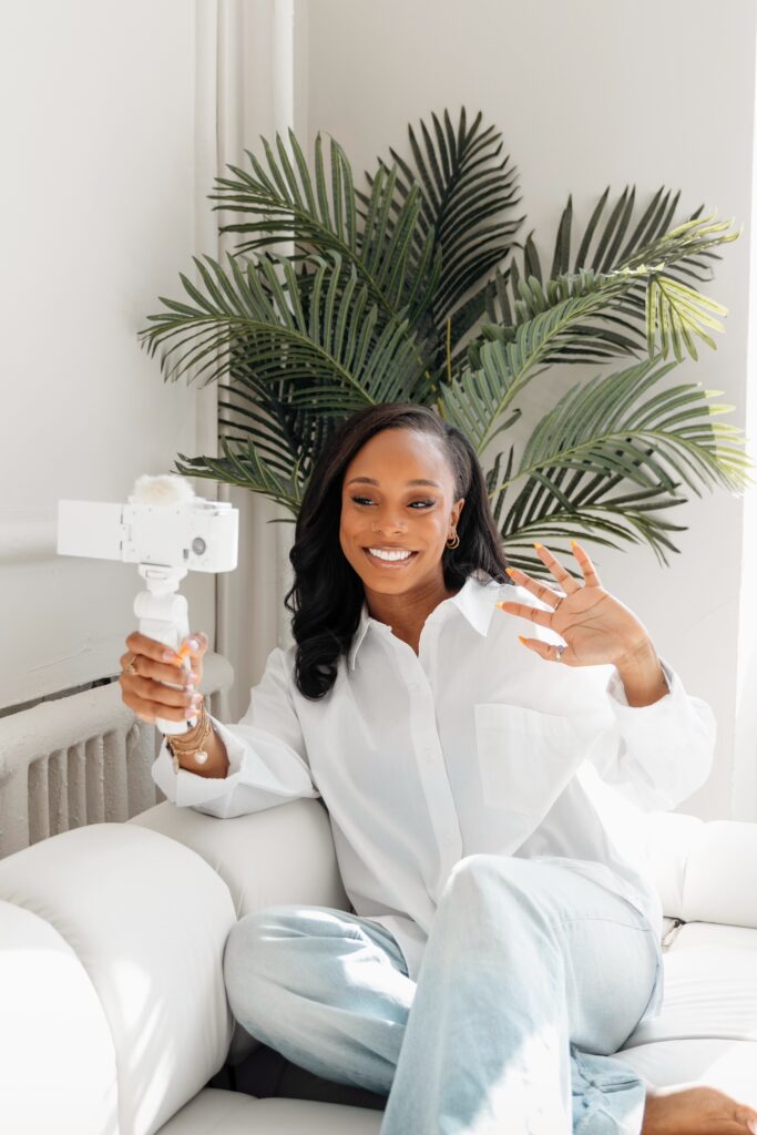 naz smiling and waving at her vlog camera